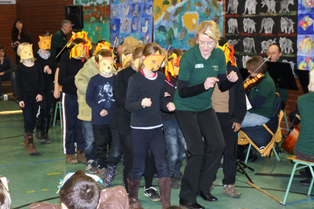 Kinder und Dozentin beim Einstudieren der Löwen für den "Karneval der Tiere"