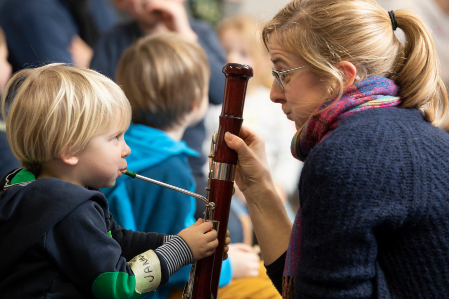 kleines Kind bläst in Fagott bei Musik mit Pfiff 