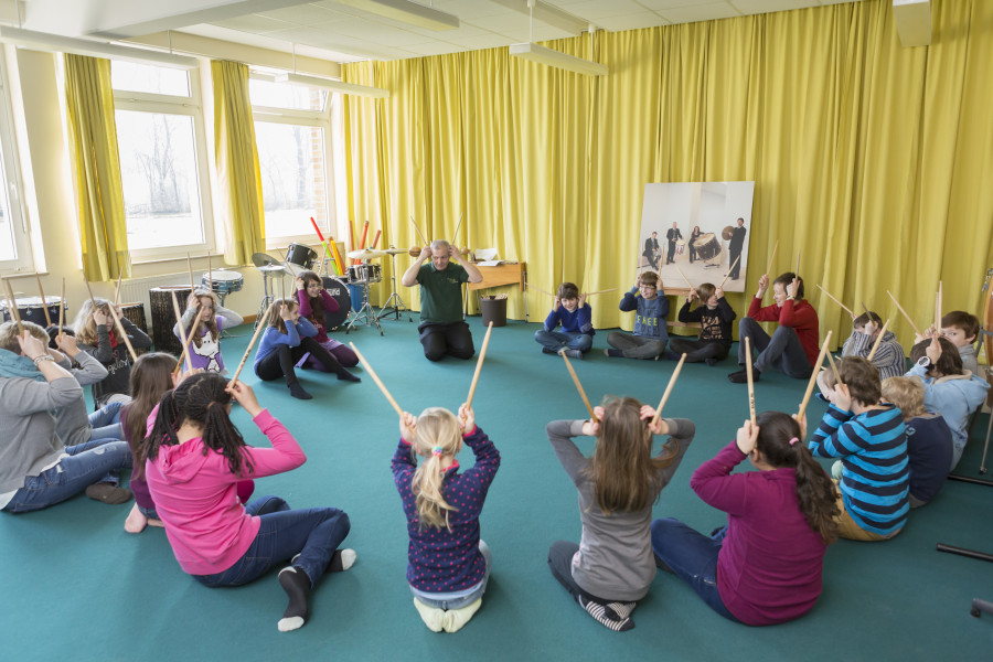 Kinder im Sitzkreis mit Sticks als Fühler am Kopf